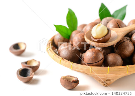 Macadamia Nut Kernel on Wooden Spoon with Basket of Whole Nuts Isolated on White Background Macadamia Nut Kernel on Wooden Spoon with Basket of Whole Nuts Isolated on White Background 140324735