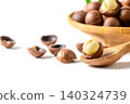 Macadamia Nut Kernel on Wooden Spoon with Cracked Shells and Basket on White Background 140324739