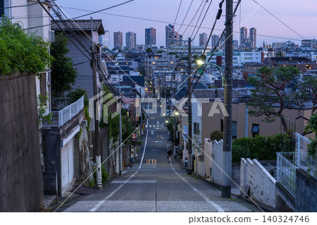 A sloping residential street in Higashi-Yukigaya, Ota Ward, Tokyo, and a night view of the tower apartments in Musashi-Kosugi. A sloping residential street in Higashi-Yukigaya, Ota Ward, Tokyo, and a night view of the tower apartments in Musashi-Kosugi. 140324746