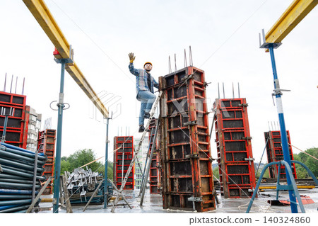 Construction worker on ladder building concrete column formwork Construction worker on ladder building concrete column formwork 140324860