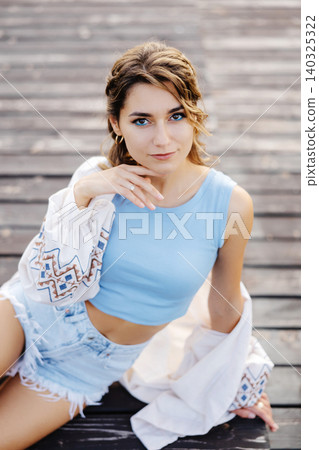 Woman sitting on top of wooden floor 140325322