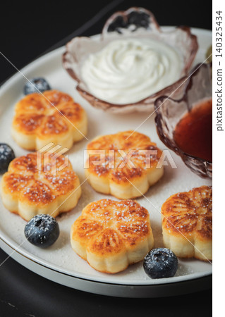 Cottage cheese pancakes, syrniki, curd fritters decorated with strawberry and raspberry served on a white plate. Homemade breakfast concept Cottage cheese pancakes, syrniki, curd fritters decorated with strawberry and raspberry served on a white plate. Homemade breakfast concept 140325434