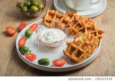 Top view of Homemade Potato Waffles, ricotta cheese and mayonese sauce. Served with tomatoes and basil leaves. Vegetarian meel Top view of Homemade Potato Waffles, ricotta cheese and mayonese sauce. Served with tomatoes and basil leaves. Vegetarian meel 140325438