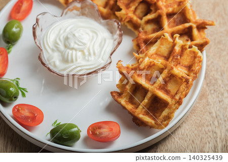 Top view of Homemade Potato Waffles, ricotta cheese and mayonese sauce. Served with tomatoes and basil leaves. Vegetarian meel Top view of Homemade Potato Waffles, ricotta cheese and mayonese sauce. Served with tomatoes and basil leaves. Vegetarian meel 140325439