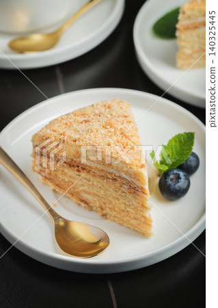 Medovik. Honey cake made from honey cakes with whipped sour cream, decorated with berries, pomegranate and flowers Medovik. Honey cake made from honey cakes with whipped sour cream, decorated with berries, pomegranate and flowers 140325445