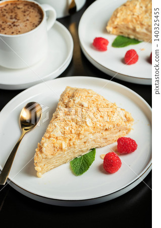 Sliced Napoleon cake on a white wooden table. Classic dessert 140325455