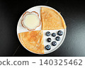 Pancakes with blueberry and honey on a white plate 140325462