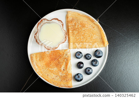 Pancakes with blueberry and honey on a white plate 140325462