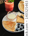 Pancakes with blueberry and honey on a white plate 140325463