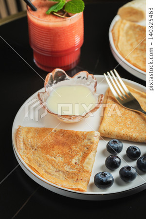 Pancakes with blueberry and honey on a white plate 140325463