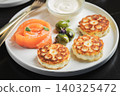 Savory Syrniki with Smoked Salmon, Olives and Sour Cream on White Plate 140325472
