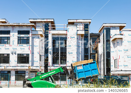 Construction site of new modern townhouses in residential neighborhood. Real Estate Exterior apartment buildings in suburbs North America. Housing development concept-Vancouver Canada-Jun 24,2022 Construction site of new modern townhouses in residential neighborhood. Real Estate Exterior apartment buildings in suburbs North America. Housing development concept-Vancouver Canada-Jun 24,2022 140326085