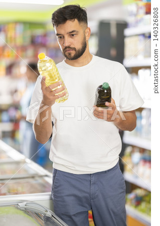 Buyer view assortment, man choose vegetable oil Buyer view assortment, man choose vegetable oil 140326808