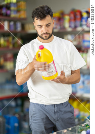 Middle-aged man choosing detergent in big supermarket Middle-aged man choosing detergent in big supermarket 140326814