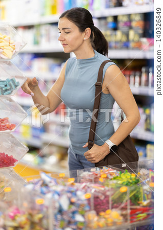 In supermarket woman choose jelly sweets In supermarket woman choose jelly sweets 140326849