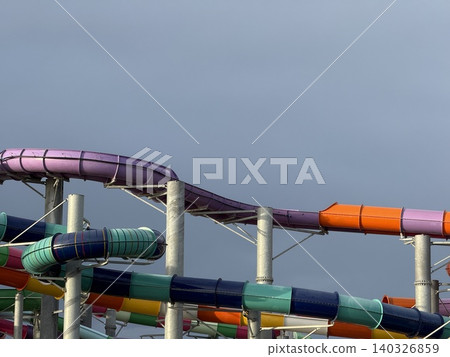 Colorful water park slides weaving against clear sky background Colorful water park slides weaving against clear sky background 140326859