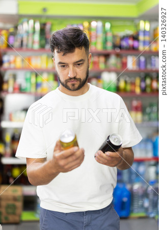 Man customer in supermarket search, choose product beer Man customer in supermarket search, choose product beer 140326927