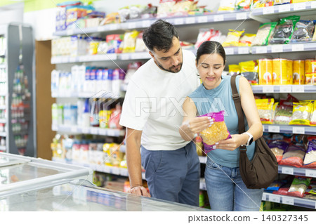 Middle-aged choosing dried corn kernels in supermarket Middle-aged choosing dried corn kernels in supermarket 140327345