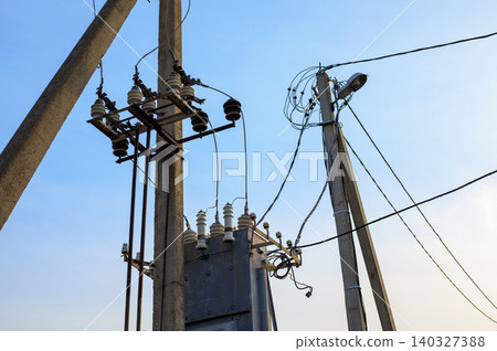 High voltage electrical transformer station on concrete poles, utility power grid line system against clear blue sky High voltage electrical transformer station on concrete poles, utility power grid line system against clear blue sky 140327388