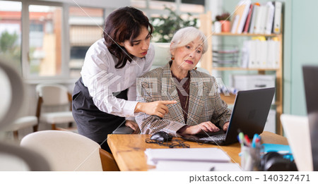 Young woman helping elderly woman with laptop Young woman helping elderly woman with laptop 140327471