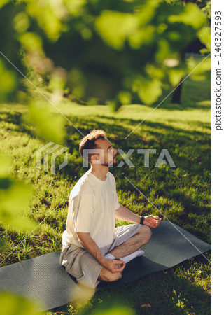 an Meditating Outdoors In Morning Sunlight an Meditating Outdoors In Morning Sunlight 140327593