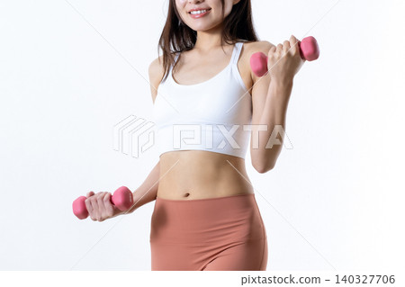 A woman lifting dumbbells to work out her body; dumbbell curls; female muscle training; angled view; body trimming up. 140327706