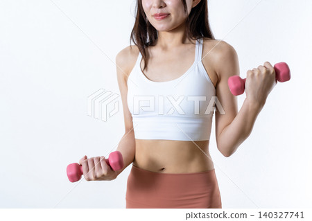A woman lifting dumbbells to work out; dumbbell curls; female weightlifter; front view; face not visible. A woman lifting dumbbells to work out; dumbbell curls; female weightlifter; front view; face not visible. 140327741