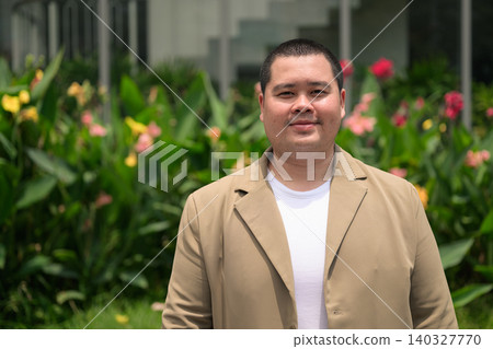 Confident plus size Isan Thai businessman in flower garden horizontal 140327770