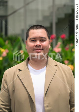 Confident plus size Isan Thai businessman in flower garden vertical Confident plus size Isan Thai businessman in flower garden vertical 140327771