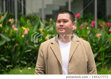 Pensive plus size Isan Thai businessman in flower garden horizontal 140327772