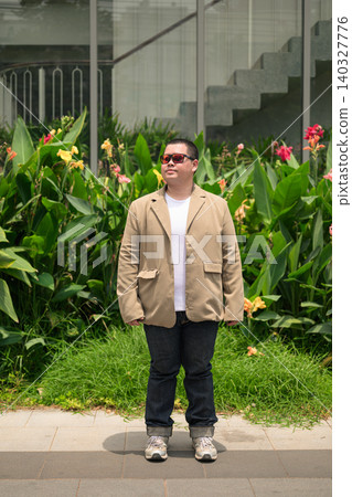 Pensive plus size Isan Thai man with sunglasses in garden vertical Pensive plus size Isan Thai man with sunglasses in garden vertical 140327776