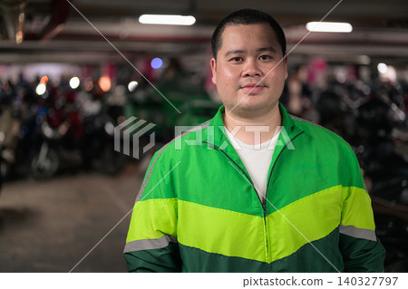 Thai delivery man from Isan looking at camera in motorcycle parking garage Thai delivery man from Isan looking at camera in motorcycle parking garage 140327797