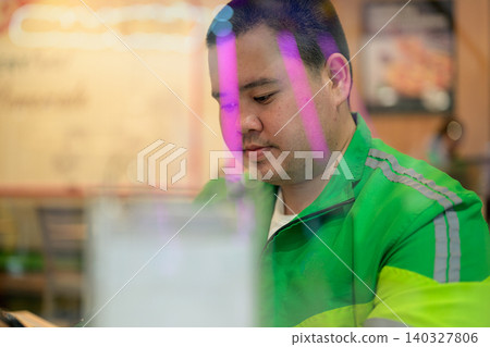 Thai delivery man from Isan sitting inside restaurant behind window reflection Thai delivery man from Isan sitting inside restaurant behind window reflection 140327806