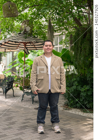 Confident plus size Isan Thai businessman in green garden vertical full length portrait Confident plus size Isan Thai businessman in green garden vertical full length portrait 140327926