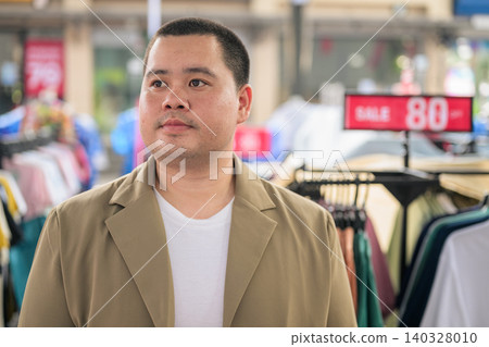 Plus size Isan Thai businessman looking away at an outdoor market Plus size Isan Thai businessman looking away at an outdoor market 140328010