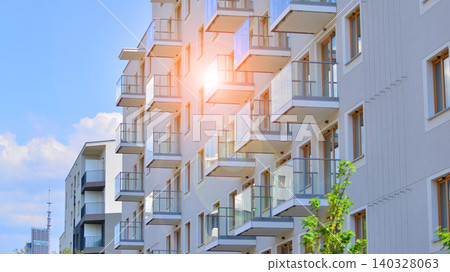 View of modern residential building with glass balconies and bright facade. Contemporary apartment building in european city. Concept of urban living and modern architecture. View of modern residential building with glass balconies and bright facade. Contemporary apartment building in european city. Concept of urban living and modern architecture. 140328063