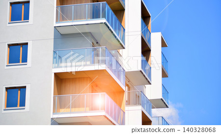 View of modern residential building with glass balconies and bright facade. Contemporary apartment building in european city. Concept of urban living and modern architecture. View of modern residential building with glass balconies and bright facade. Contemporary apartment building in european city. Concept of urban living and modern architecture. 140328068