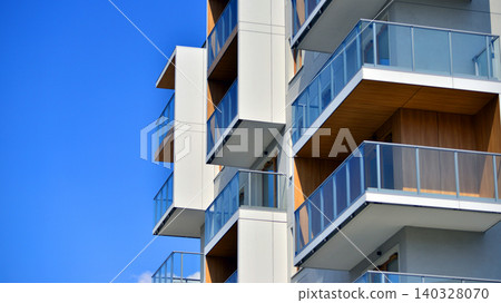 View of modern residential building with glass balconies and bright facade. Contemporary apartment building in european city. Concept of urban living and modern architecture. View of modern residential building with glass balconies and bright facade. Contemporary apartment building in european city. Concept of urban living and modern architecture. 140328070