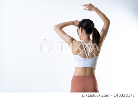 A slender woman who works out poses from behind; muscle training girl, weight loss, diet. A slender woman who works out poses from behind; muscle training girl, weight loss, diet. 140328175