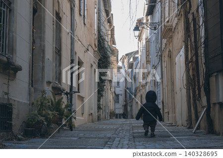 Toddler exploring narrow old town street in france Toddler exploring narrow old town street in france 140328695