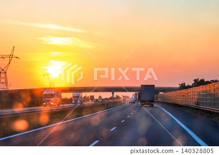 Highway traffic under the bridge during sunset with trucks and cars through a dirty windshield. Transportation, logistics, road safety and challenges of visibility. Poland, A2. Copy space Highway traffic under the bridge during sunset with trucks and cars through a dirty windshield. Transportation, logistics, road safety and challenges of visibility. Poland, A2. Copy space 140328805