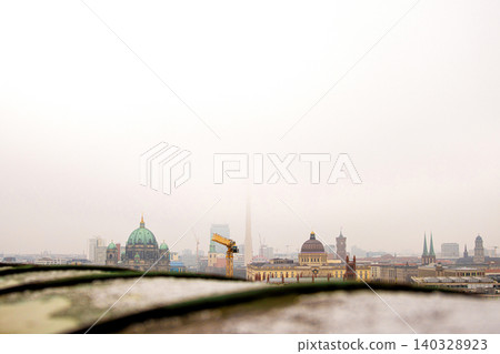 Berlin skyline with historic and modern sights. Panoramic birds eye view of foggy Berlin from the rooftop of French Church. Historic and modern landmarks on a misty day. Copy space Berlin skyline with historic and modern sights. Panoramic birds eye view of foggy Berlin from the rooftop of French Church. Historic and modern landmarks on a misty day. Copy space 140328923