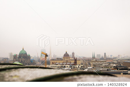 Berlin skyline with historic and modern sights. Panoramic birds eye view of foggy Berlin from the rooftop of French Church. Historic and modern landmarks on a misty day. Copy space Berlin skyline with historic and modern sights. Panoramic birds eye view of foggy Berlin from the rooftop of French Church. Historic and modern landmarks on a misty day. Copy space 140328924