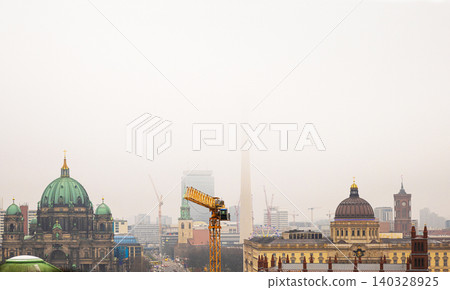Berlin skyline with historic and modern sights. Panoramic birds eye view of foggy Berlin from the rooftop of French Church. Historic and modern landmarks on a misty day. Copy space Berlin skyline with historic and modern sights. Panoramic birds eye view of foggy Berlin from the rooftop of French Church. Historic and modern landmarks on a misty day. Copy space 140328925