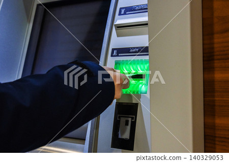 Closeup of a bank client hand inserting a bank card into an atm bank terminal for cash withdrawal, banking transaction, digital payment. Money management, security, financial services concept Closeup of a bank client hand inserting a bank card into an atm bank terminal for cash withdrawal, banking transaction, digital payment. Money management, security, financial services concept 140329053