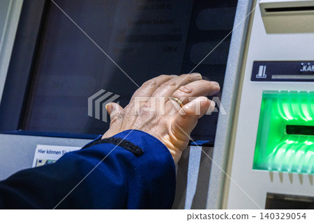 Bank client interacting with an ATM touchscreen interface, selecting options on cashpoint display. Closeup of clients hand entering information on cash mchine terminal. Bank client interacting with an ATM touchscreen interface, selecting options on cashpoint display. Closeup of clients hand entering information on cash mchine terminal. 140329054