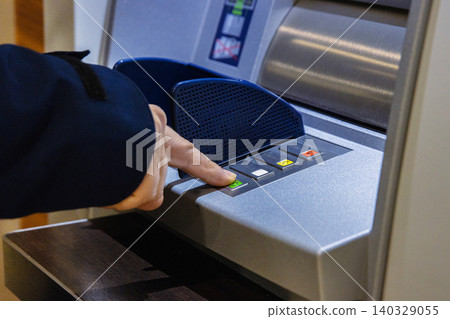 Person using modern ATM machine. Closeup of a finger  pressing a button on an ATM interface for cash withdrawal or account management, symbolizing financial transactions and banking solutions. 140329055