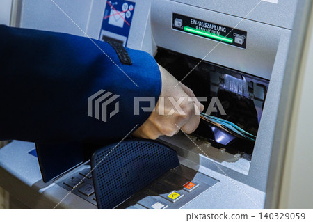 Closeup of a person withdrawing cash from an atm. Customer taking banknotes from an cash machine, symbolizing digital finance, personal banking, and financial management in the modern economy. 140329059