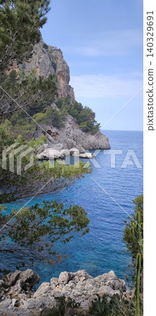 A picturesque bay with crystal clear turquoise water and a rocky shore A picturesque bay with crystal clear turquoise water and a rocky shore 140329691