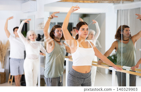 Group of different people doing ballet at barre Group of different people doing ballet at barre 140329903